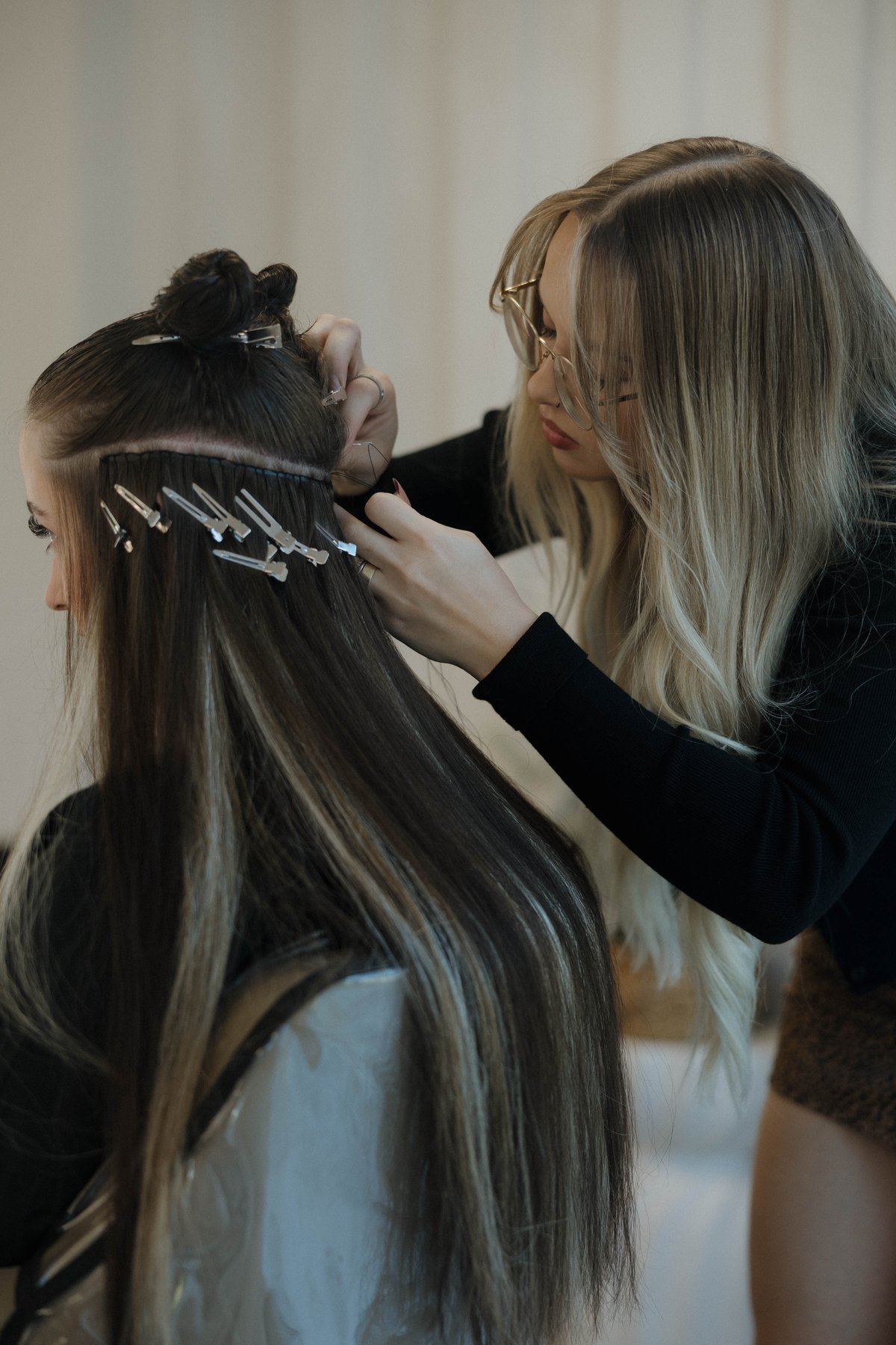 A hand-tied weft row mid-install at Luxe & Mane Co
